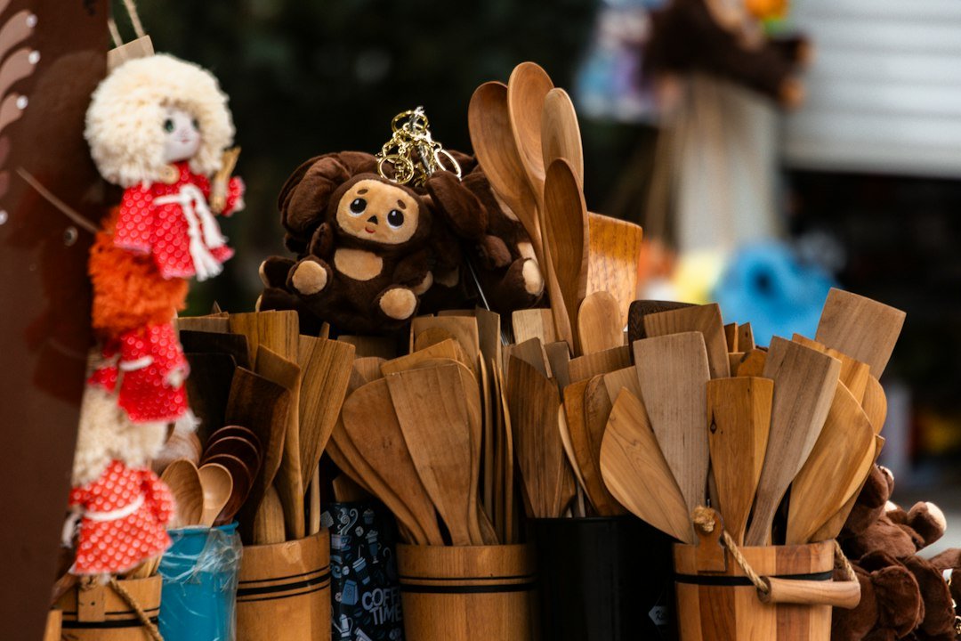 Wooden kitchen utensils and stuffed toys on display