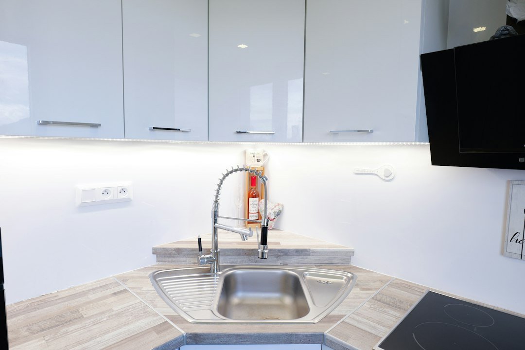 Modern kitchen sink with white cabinets and countertop